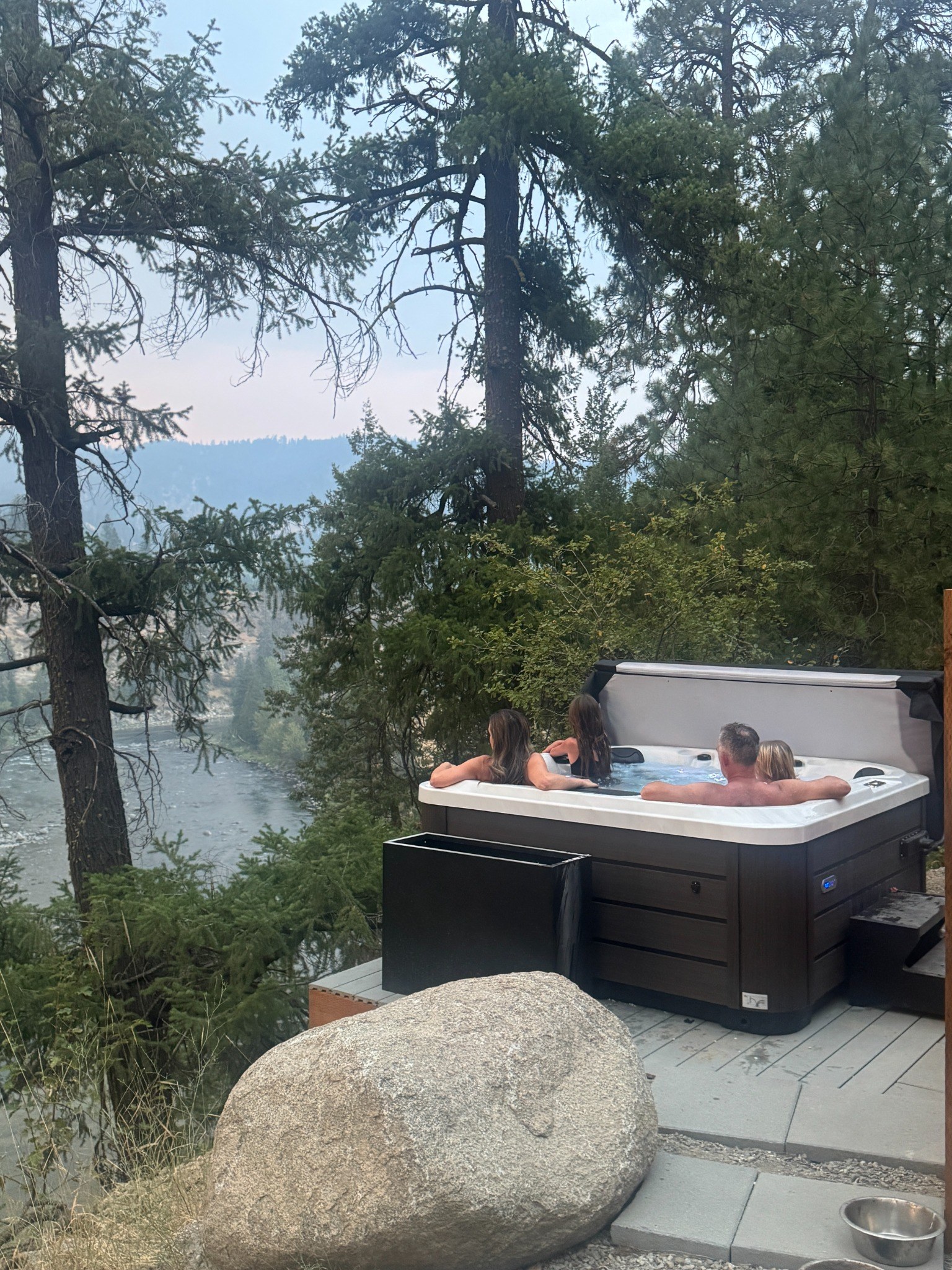 Guests relaxing in the private hot tub above the Wenatchee River